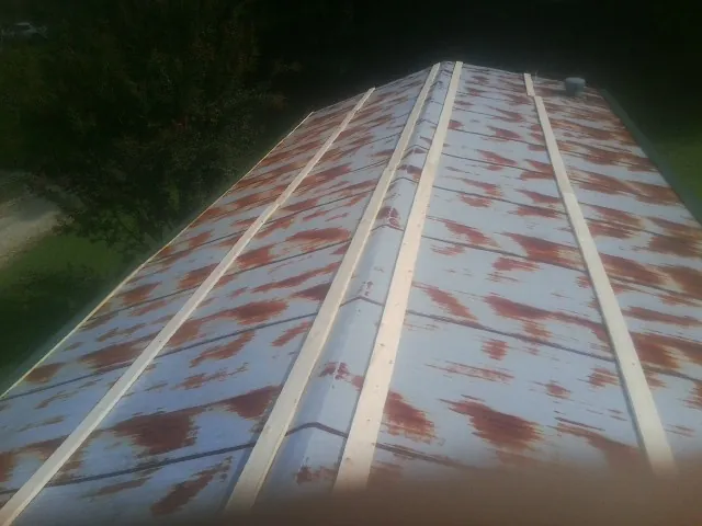Rusted metal roof panels with new wood purlins before replacement — Storm Damage Roof Repair in Alpena by Roofing Brothers