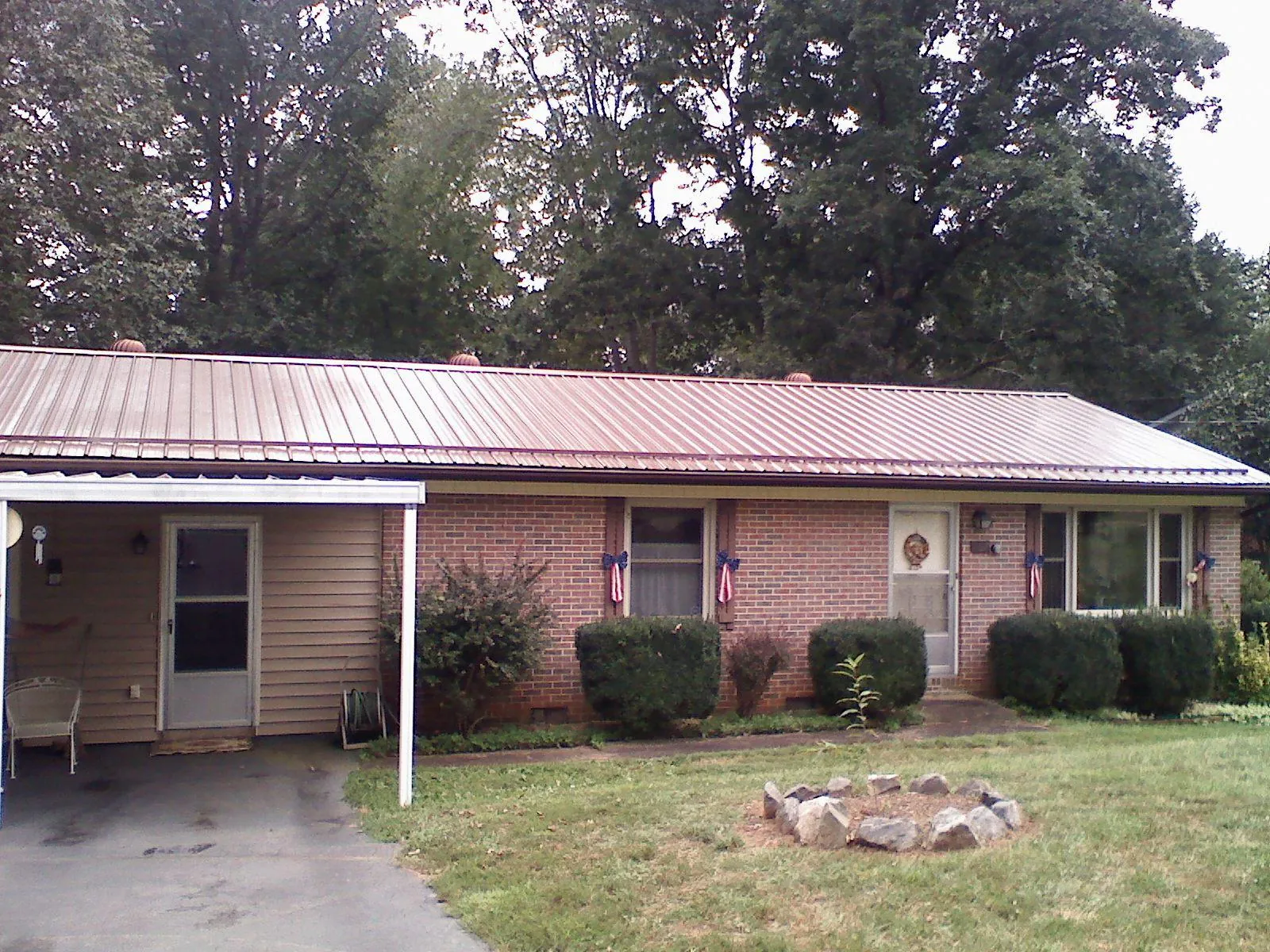 Bronze metal roof and carport on a brick ranch home — Roof Repair work by our crew in Alpena